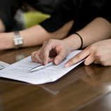 Person holding a pen and documents