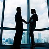 Two business people shaking hands in an office building