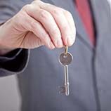 Business man holding a property key