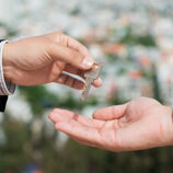 Person handing another person a key