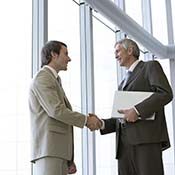 Two business men shaking hands in an office building